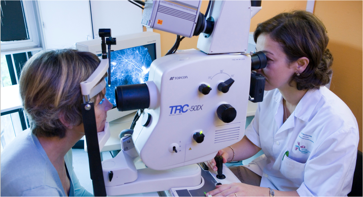 dryAMD.eu Femme praticienne examinant l'œil d'un patient avec une angiographie à la fluorescéine du fond de l'œil.