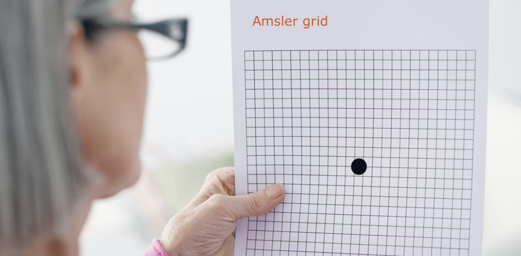 dryAMD.eu A woman wearing reading glasses performs an Amsler Grid Test.
